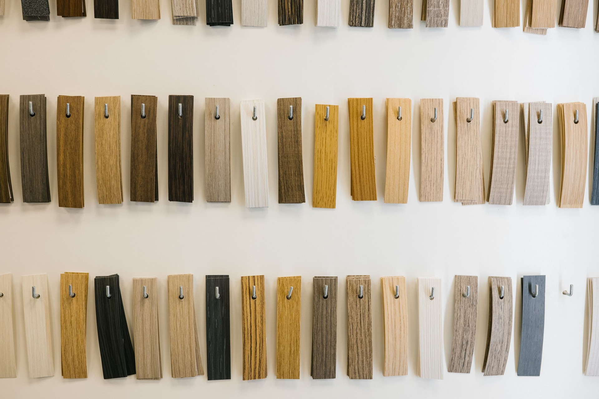 Collection of wooden sample swatches displayed on wall in various shades and textures